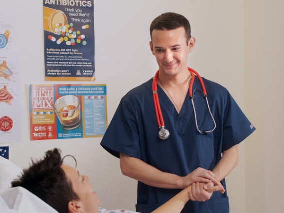 Medical student holding patient's hand